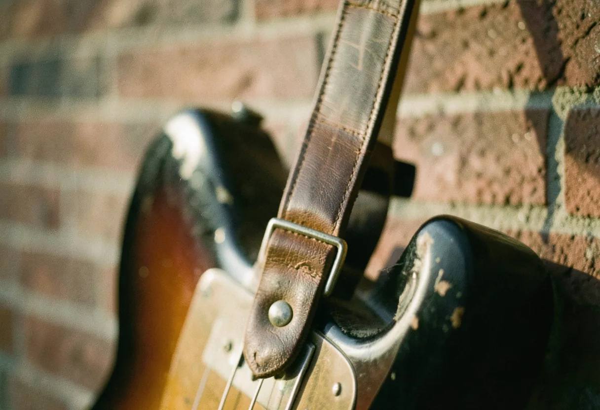 Worn leather guitar strap, muted tones, soft lighting, best guitar straps for heavy stratocasters.